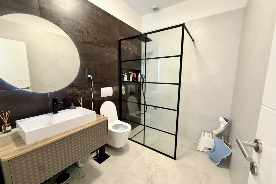 Bathroom with stylish furnishings and glass shower cubicle
