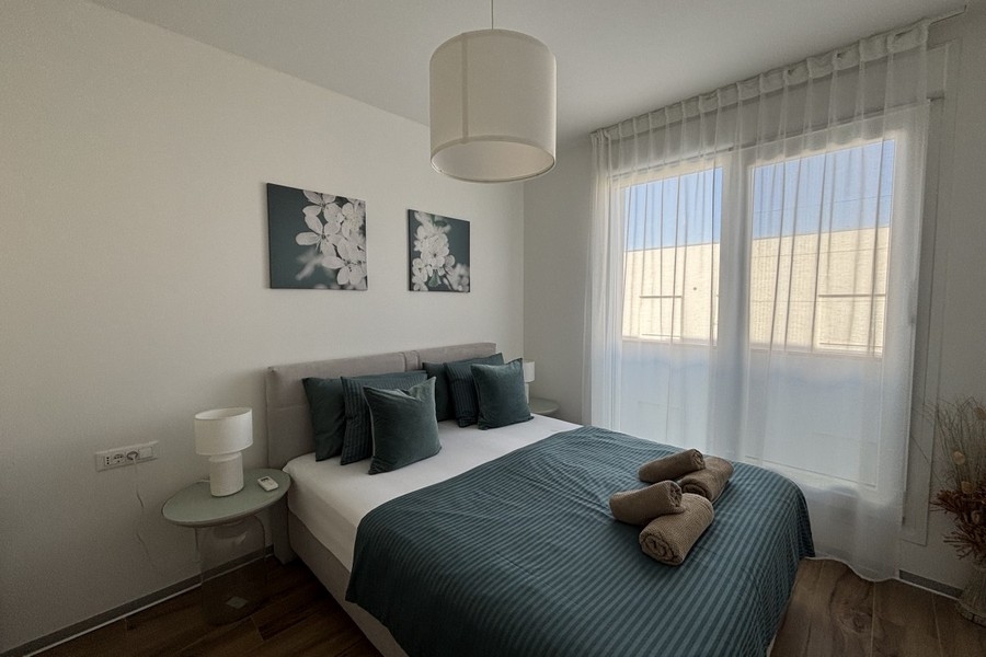 Bedroom with double bed and large windows