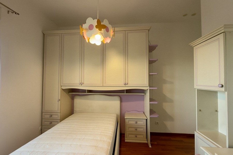 Bedroom with single bed and custom fitted wardrobes