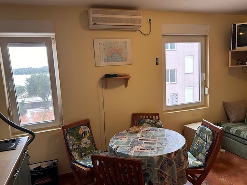 Living and dining area with a round table group and sea views through the window