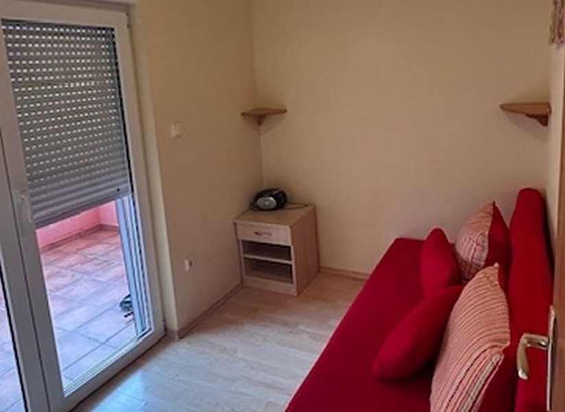 Bedroom with red sofa and access to the balcony