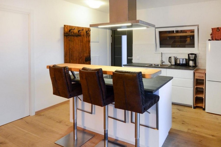 Modern kitchen with island and bar stools in the living area