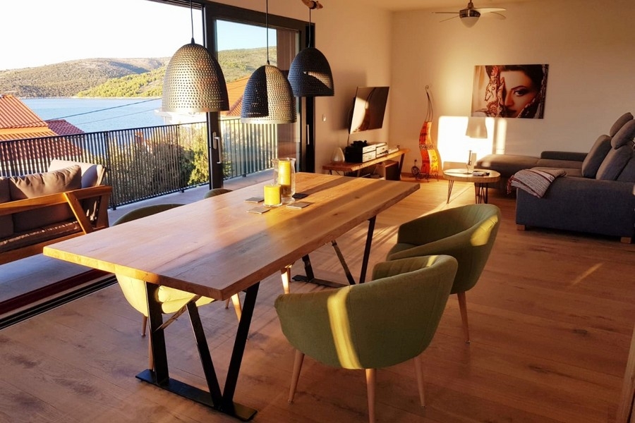 Open living area with sofa, dining table and access to the balcony