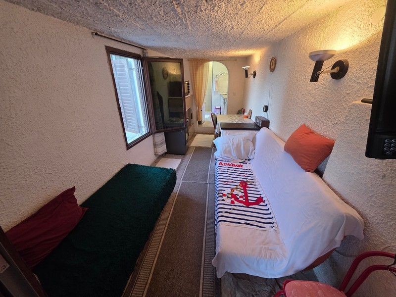 Narrow living room with seating and window facing the street