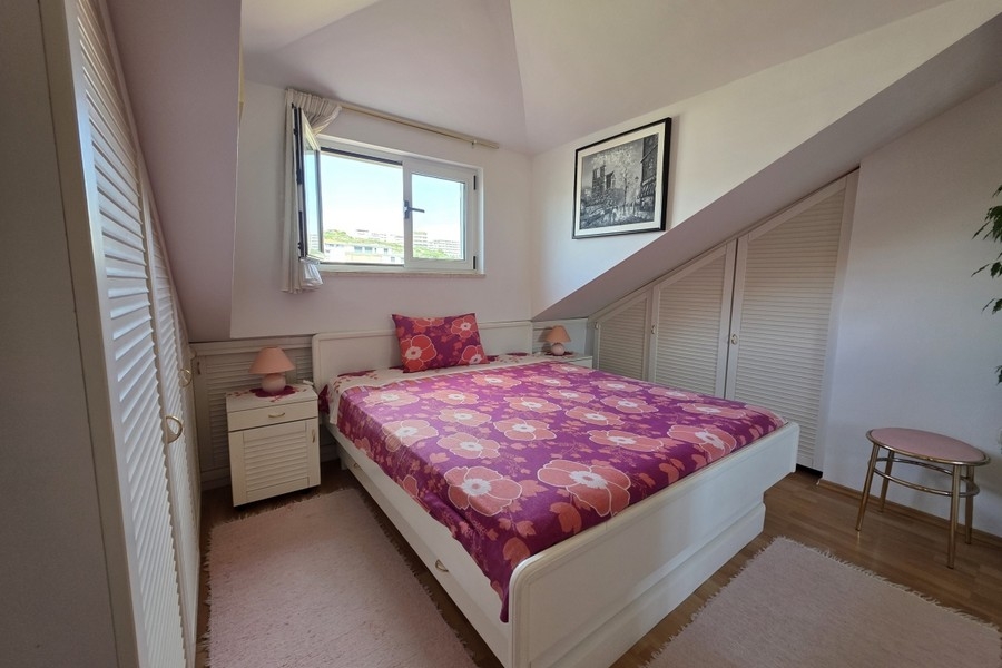 Bedroom with double bed and fitted wardrobes in the attic with window