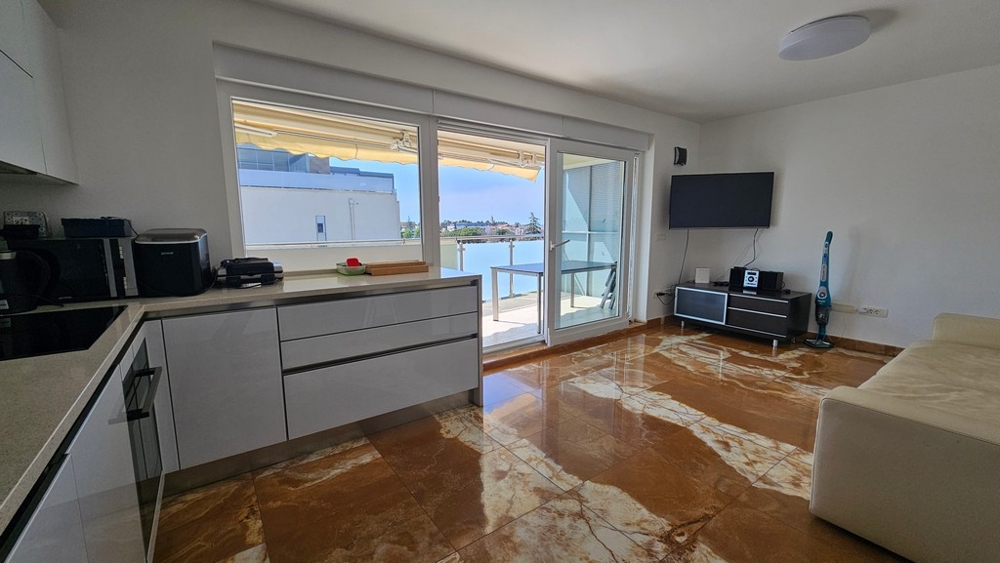 Living area with kitchen and access to the balcony with sea views