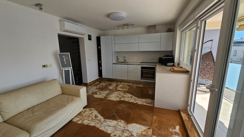 Open living room with modern fitted kitchen and terrace access