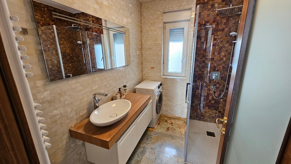 Bathroom with shower, washing machine and natural light