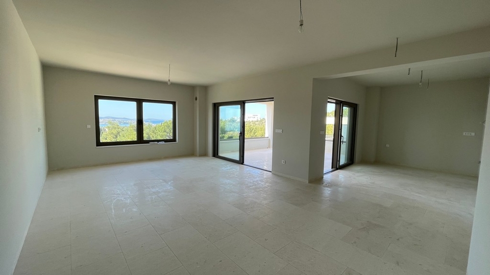 Bright open living room with large windows and sea views