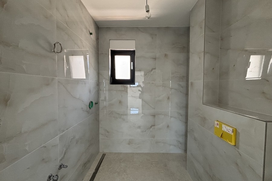 Modern bathroom with floor-level shower and window