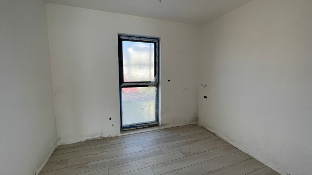 Bedroom with window and neutral furnishings in the new building