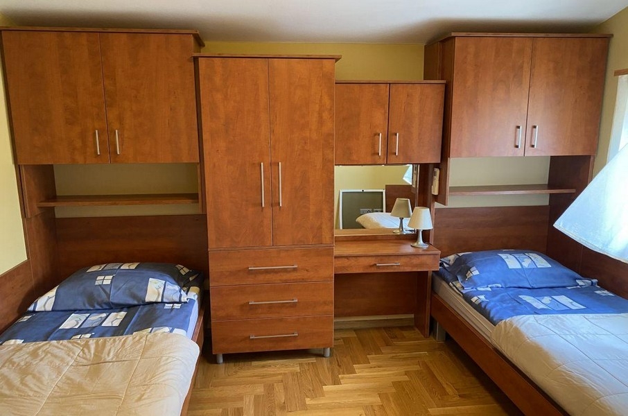 Bedroom with single beds and wooden furniture in holiday apartment