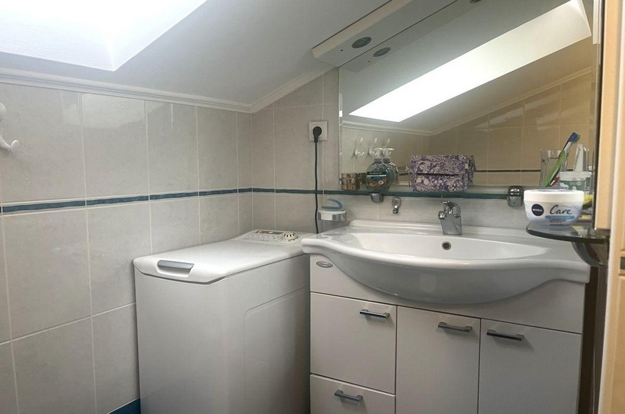 Bathroom with washing machine and sink