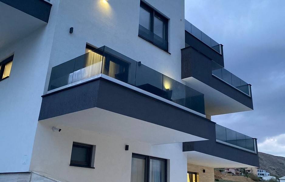 Modern residential building with balconies and glass railings in Pag