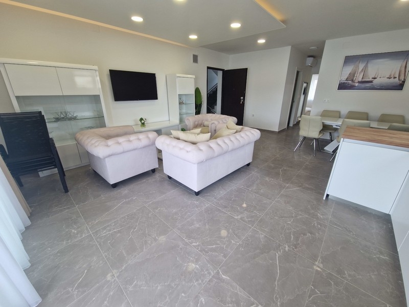 Open living area with kitchen and sea views in modern apartment