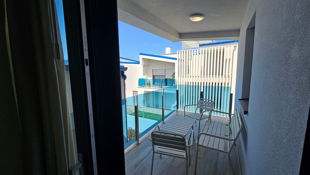 Covered balcony with glass railings and seating area