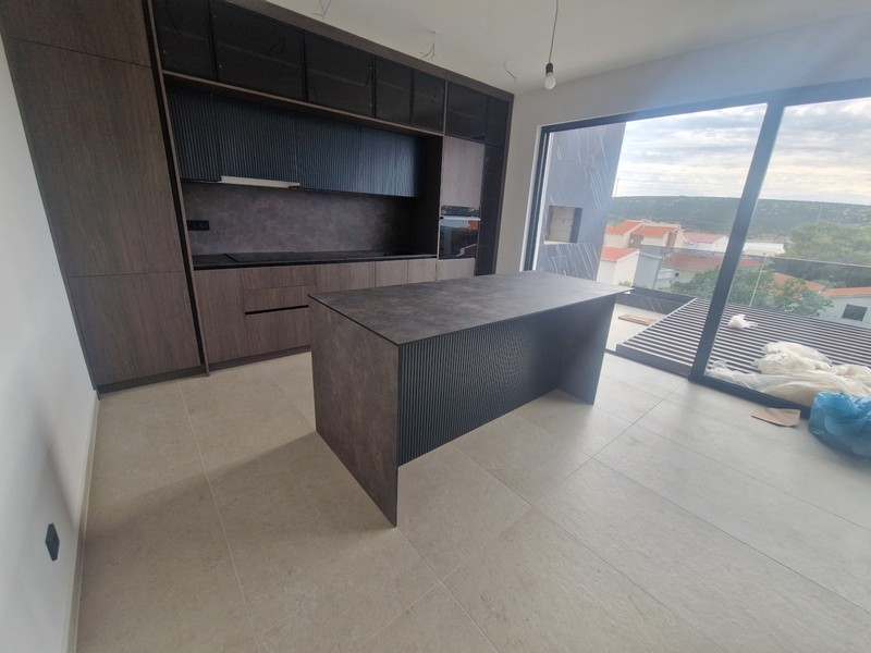 Modern fitted kitchen with cooking island and sea views