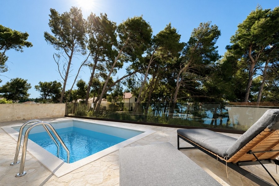 Pool area with sun loungers and coastal views
