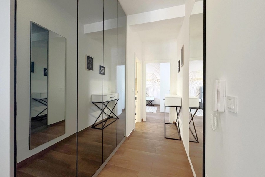 Bright entrance area with fitted wardrobes and wood-look flooring
