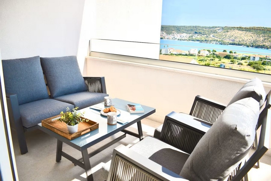 Covered terrace with seating area and sea views