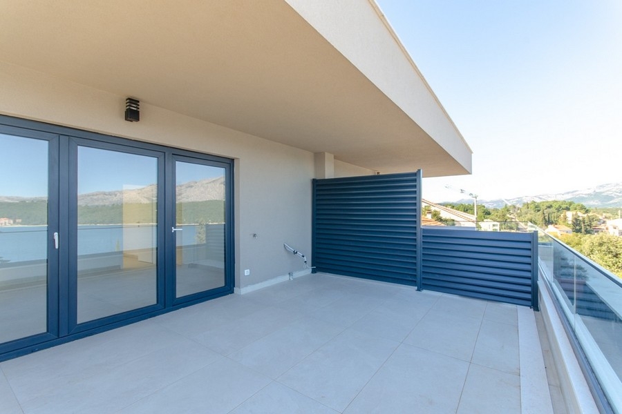 Covered terrace with glass railings and sea views