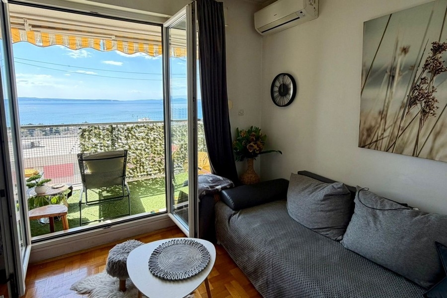 Bright living area with air conditioning and balcony access