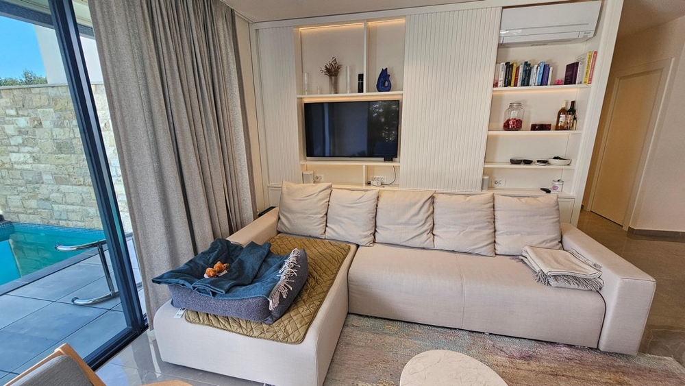 Living area with sofa, television and pool access