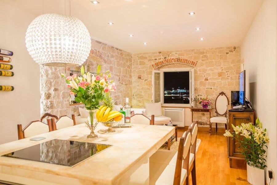 Dining area with natural stone walls and parquet floors