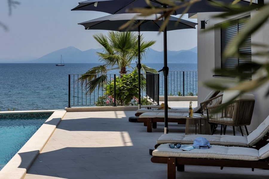 Pool terrace with palm tree and sea view