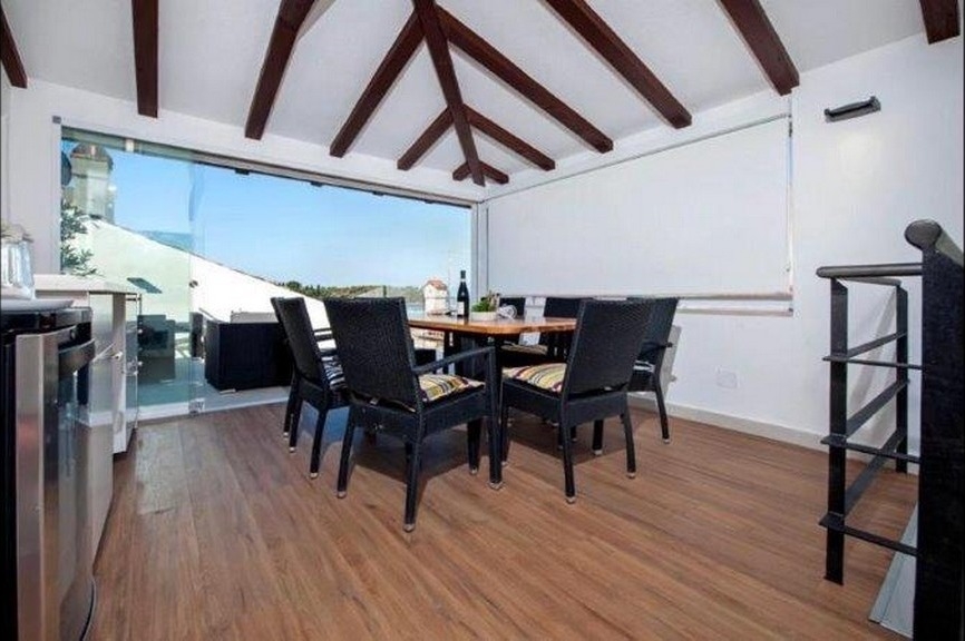 Dining area with beamed ceiling and terrace access