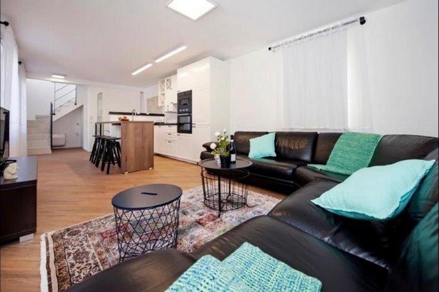 Living area with leather sofa and open kitchen