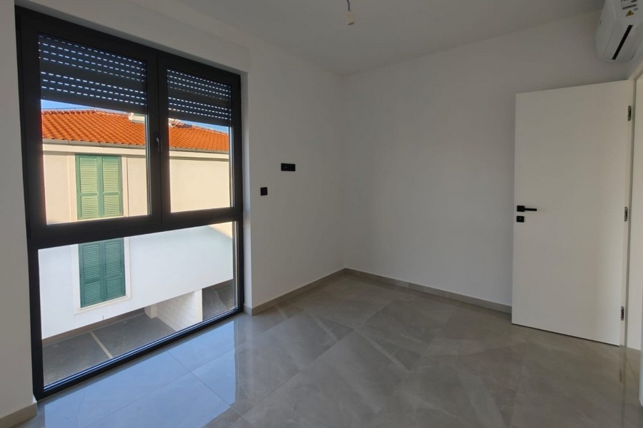 Room with window and view of red roofs
