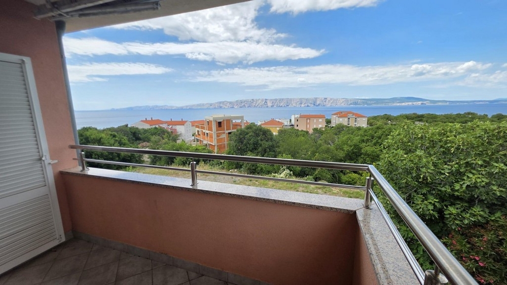 View from the balcony over greenery to the sea