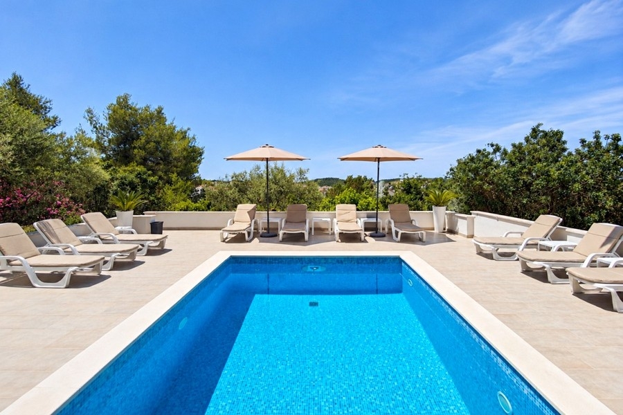 Community pool with loungers and sea views