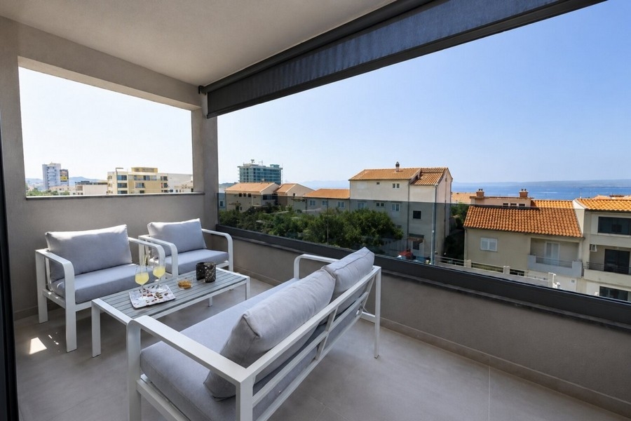 Covered terrace with lounge furniture and sea views in Makarska