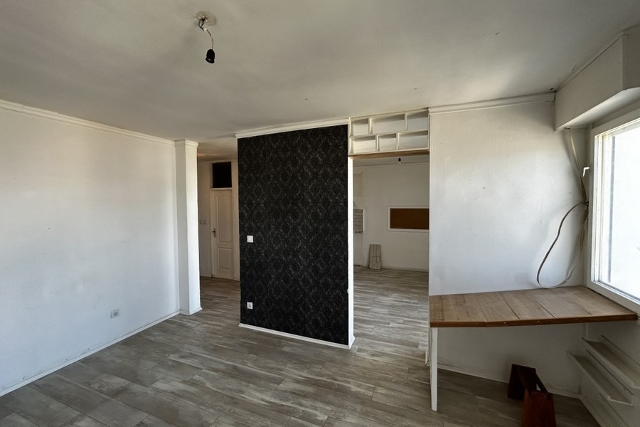 Living area with laminate flooring and floor-to-ceiling window
