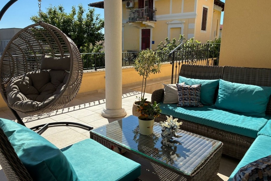 Terrace with lounge furniture and hanging chairs in Croatia