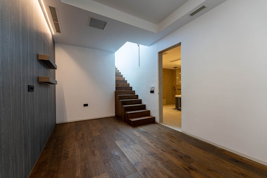 Hall with wooden stairs and bathroom in the basement