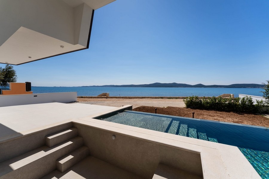 Covered terrace with steps to the pool and sea views
