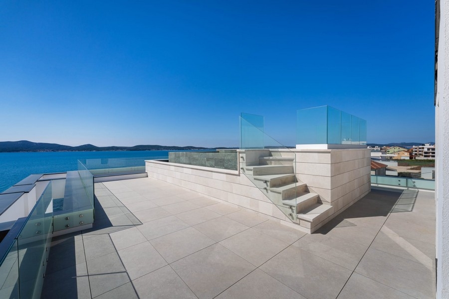 Roof terrace with stairs and glass railings by the sea