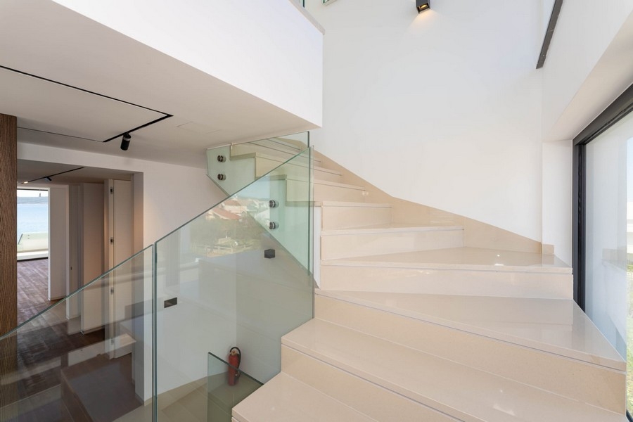 Interior staircase with glass railing in the penthouse