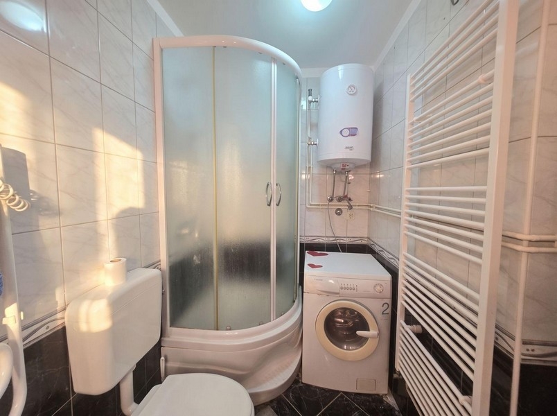 Bathroom with shower cubicle and washing machine