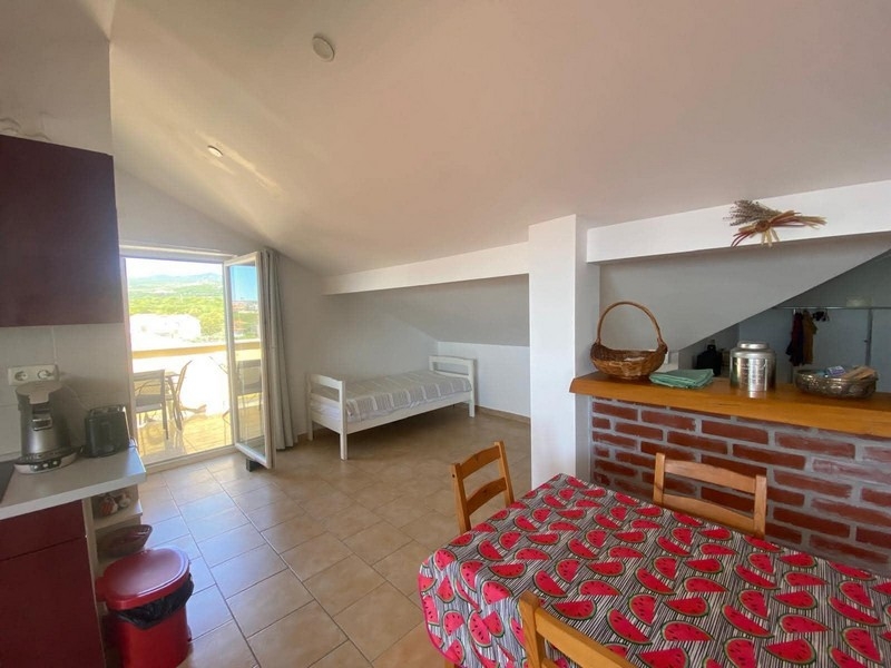 Living area with sloping ceiling and terrace access