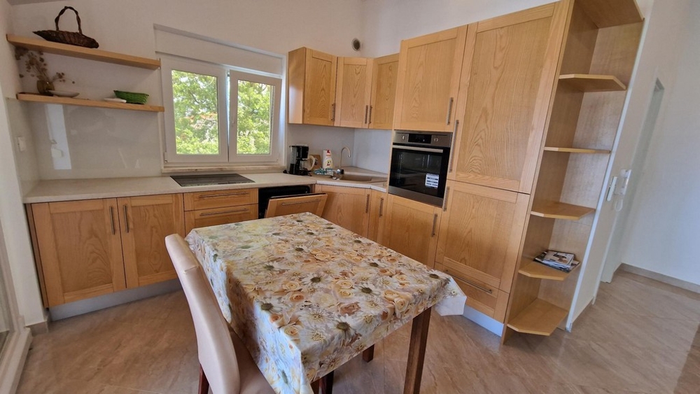 Wooden kitchenette with dining area in apartment in Njivice