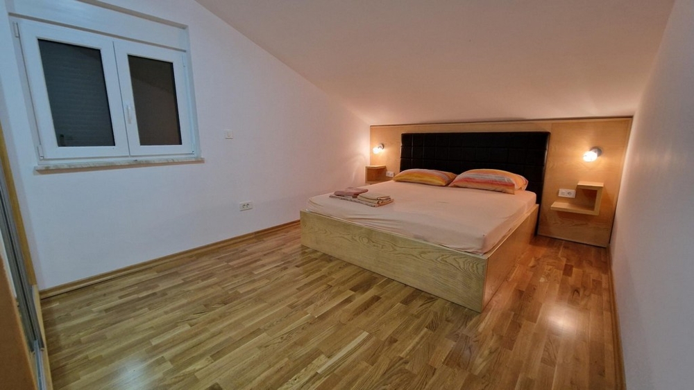 Bedroom with double bed and wooden floor in Njivice on Krk