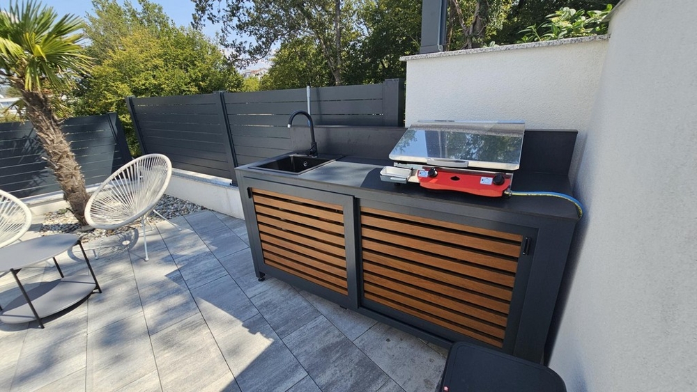 Summer kitchen with barbecue area in the garden of the apartment in Malinska