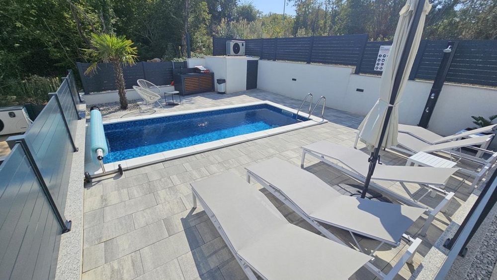 Pool and sun terrace in the apartment's own garden in Malinska