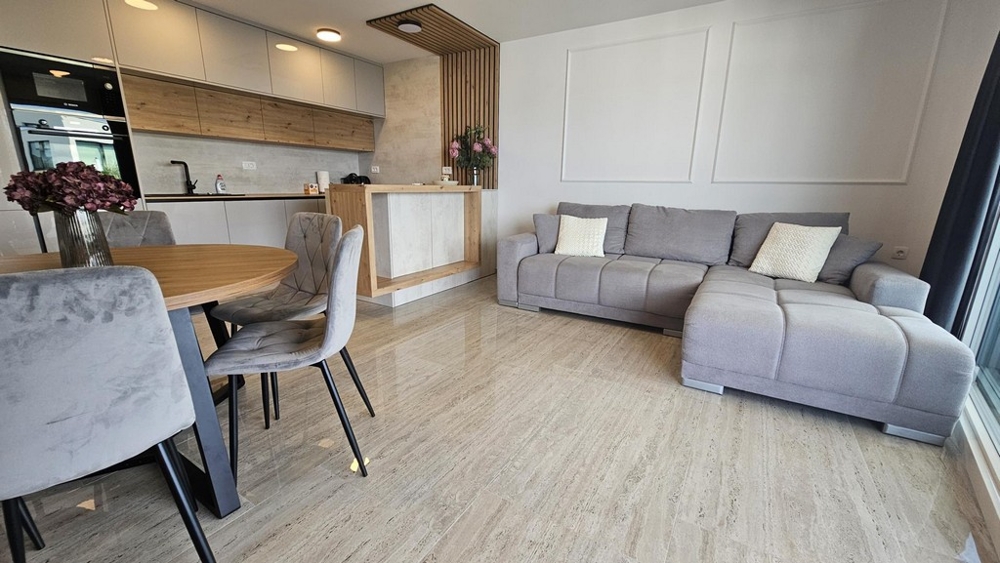Open living and kitchen area with sofa and dining table in Malinska