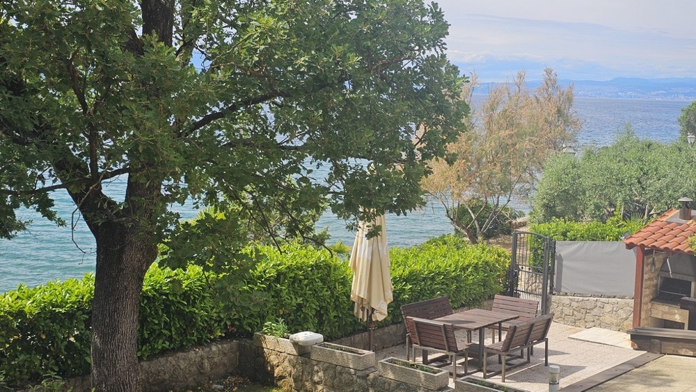 Terrace by the sea with parasol and seating in Malinska