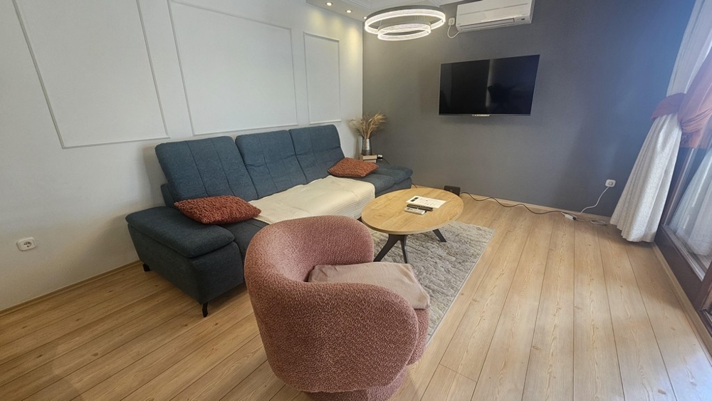 Living room with sofa and television in renovated apartment